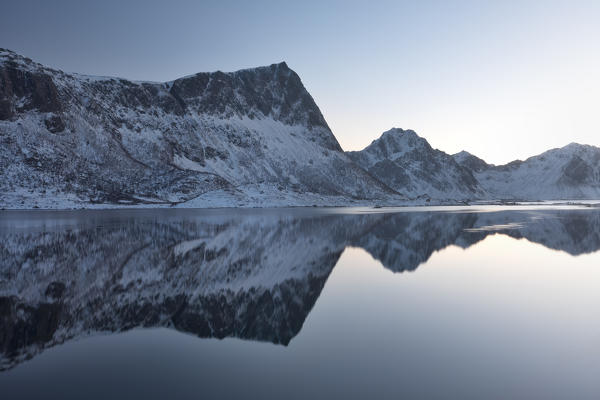 The mountains mirrored in the Voiepollen, during a blue hour of winter, Lofoten island, Northern Norway, Europe
