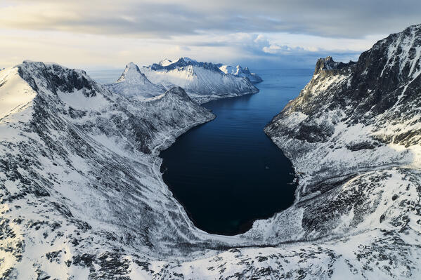 Aerial view taken from the drone of iconic Segla mountain and fjord, during a winter sunset, Senja, Norway, Europe