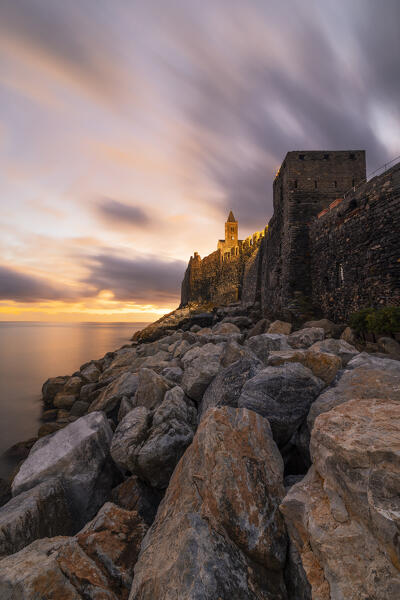 warm lights of the sunset envelope the iconic San Pietro Church during a wwinter day, Portovenere, Italy, Europe