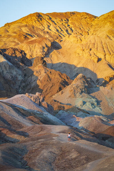 a woman admire the beautiful view at Artists Palette during a summer sunset, Death Valley National Park, California, United States of America