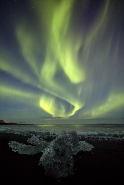 Northen Lights over block of ice in Jokulsarlon Glacier Lagoon, Austurland, Eastern Iceland, Iceland, Europe
