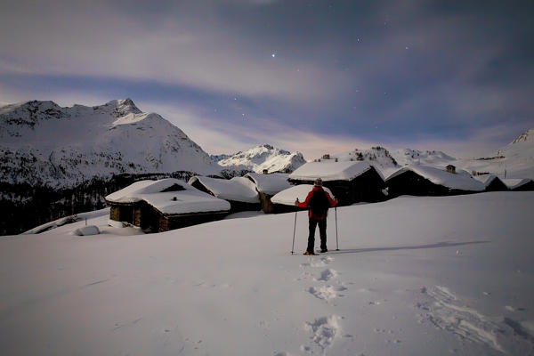 Trekker at Grevasalvas village from fulmoon in winter, Engiadin