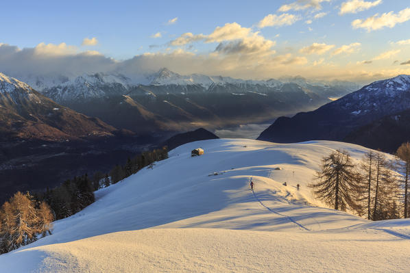 Ski mountaineer on Monte Olano at sunrise, Gerola Valley, Sondrio province, Valtellina, Lombardy, Italy