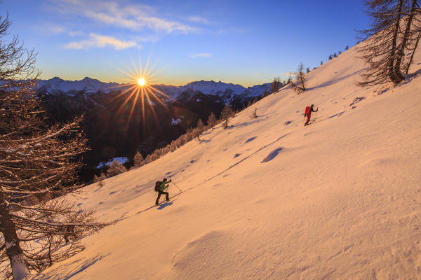 Ski mountaineers on steep slope towards Cima Rosetta, Gerola Valley, Sondrio province, Valtellina, Lombardy, Italy