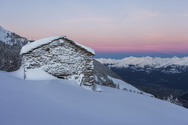 Stone hut covered with snow at sunrise, Monte Olano, Gerola Valley, Sondrio province, Valtellina, Lombardy, Italy