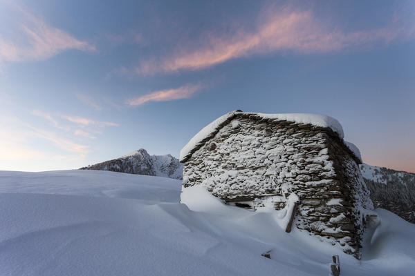 Stone hut covered with snow at sunrise, Monte Olano, Gerola Valley, Sondrio province, Valtellina, Lombardy, Italy