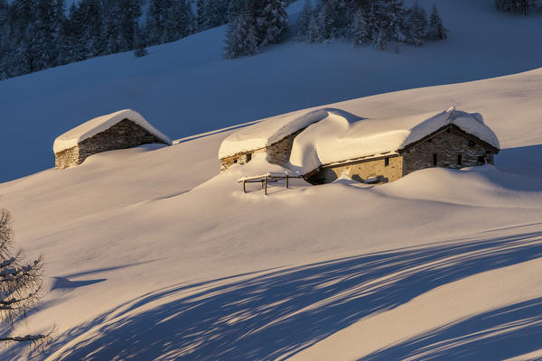 Stone huts covered with snow, Monte Olano, Gerola Valley, Sondrio province, Valtellina, Lombardy, Italy