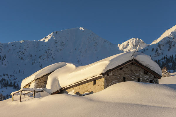 Stone huts covered with snow, Monte Olano, Gerola Valley, Sondrio province, Valtellina, Lombardy, Italy