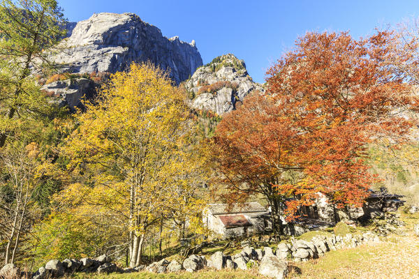 Ca di Carna during autumn framed by the peak of Monte Qualido, Val di Mello, Val Masino, Sondrio, Valtellina, Lombardy, Italy