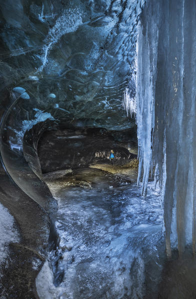 Man in an ice cave of Breidamerkurjokull, Austurland, Iceland, Northern Europe