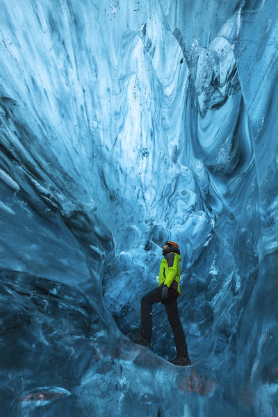 Man stands an ice cave of Breidamerkurjokull, Austurland, Iceland, Northern Europe