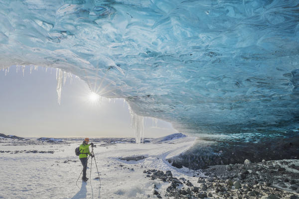 Man photographs an ice cave of Breidamerkurjokull, Austurland, Iceland, Northern Europe