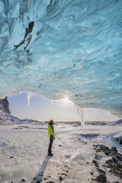 Man stands at the entrance of ice cave of Breidamerkurjokull, Austurland, Iceland, Northern Europe