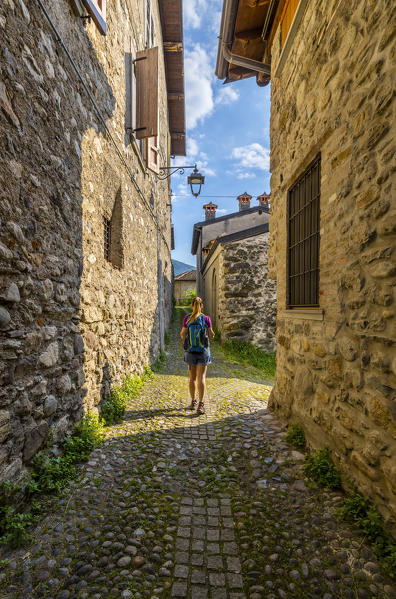 A woman walks along Strada Valeriana, Maspiano, Sale Marasino, Iseo Lake, Brescia, Lombardy, Italy, Southern Europe