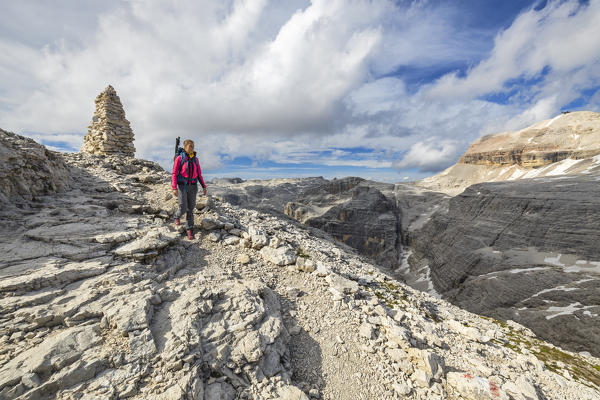 Woman walks toward Forcella Pordoi at sunset, Sass Pordoi, Belluno, Trento, Trentino Alto Adige, Veneto, Italy, Southern Europe