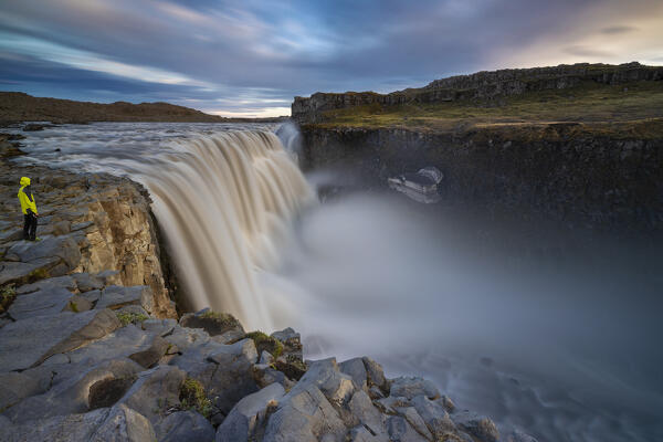 A man observes Dettifoss waterfall at its east side during midnight sun, Norðurland eystra, Iceland, Northern Europe (MR)