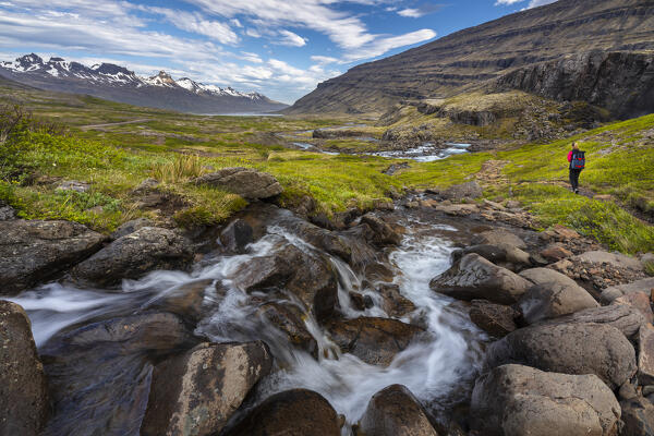 Person walks around Folaldafoss waterfall and Berufjordur during summer, Austurland, Iceland, Northern Europe 