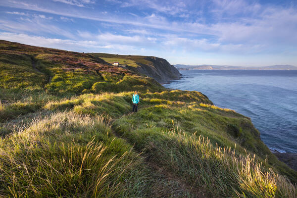 A woman walks over the cliff of the beach Barrika Hondartza, Biscaglia, Basque Country, Spain, Iberian Peninsula, Western Europe (MR)