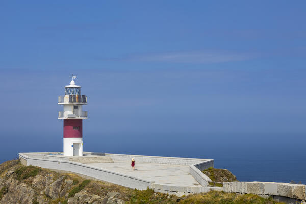 Woman at Cabo Ortegal and its lighthouse at sunrise, Cariño, Coruña, Galicia, Spain, Iberina Peninsula, Western Europe