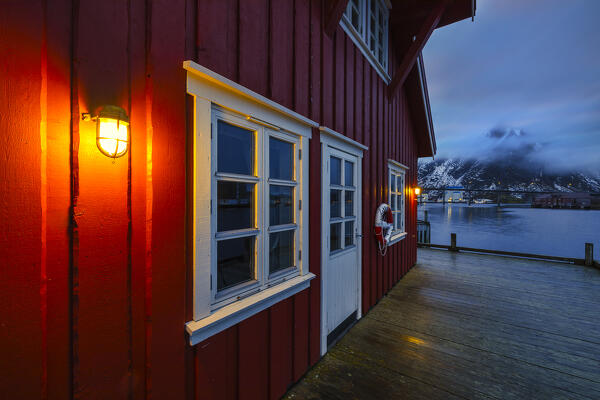 Illuminated red cottage at dusk in Svolvaer, Vagan, Austagoy, Nordland, Lofoten, Norway, Northern Europe 
