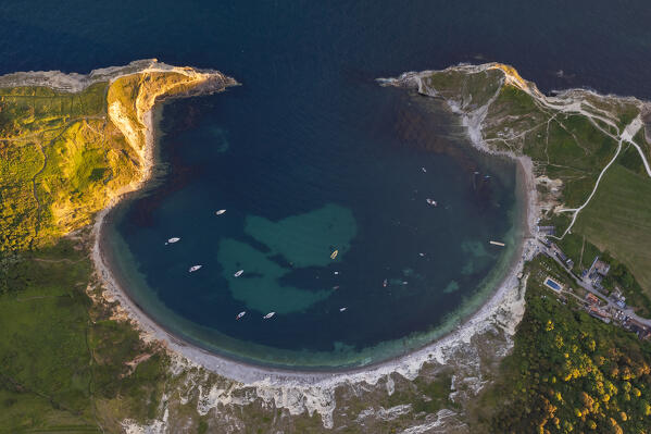 Aerial view of Lulworth Cove at sunset with boats, Durdle Door, Dorset, United Kingdom, Northern Europe