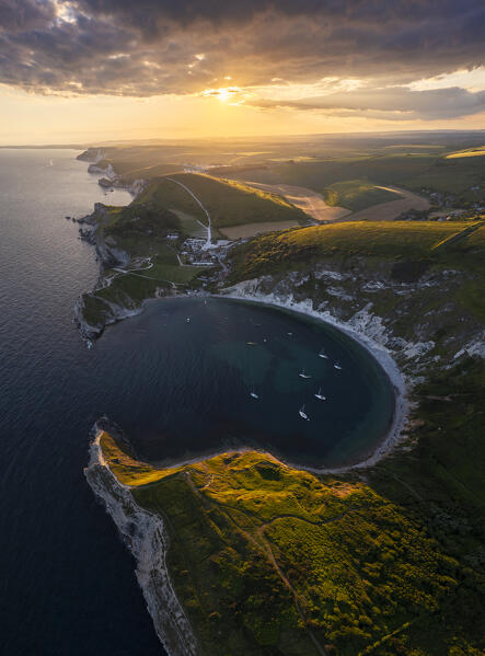 Aerial view of Lulworth Cove at sunset with boats, Durdle Door, Dorset, United Kingdom, Northern Europe