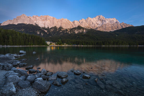 Eibsee and Zugspitze at sunset during summer with the view of illuminated Eibsee Hotel, Garmish Partenkirchen, Bavaria, Germany, Deutschland, Western europe
