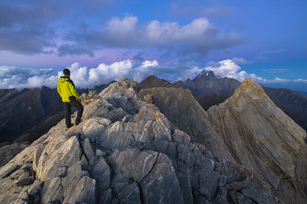 A trekker observes Monviso from Pain de Sucre during dusk at summer, Pain de Sucre, Col Agnel, Alpi Cozie, Alpi del Monviso, Cuneo, Piedmont, Italy, Southern Europe 