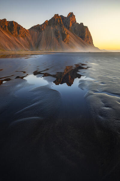Vestrahorn reflected in the black sand beach at sunrise, Stokksnes peninsula, Hofn, Austurland, Iceland , Northern Europe