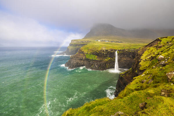 Mulafossur waterfall and Arnafjall and Heinanova mountains with rainbow, Gasadalur, Vagar, Faroe Islands, Denmark, Scandinavia