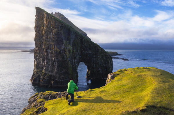 A photographer photographs Drangarnir at sunset, Vagar, Faroe Islands, Denmark, Scandinavia