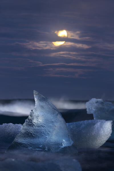 Block of ice in front of the Moon at Diamon beach during dusk, Jökulsárlón, Diamond beach, Austurland, Iceland, Northern Europe
