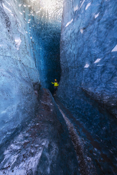 Man observes an ice cave of Breidamerkurjokull, austurland, Iceland, Northern Europe