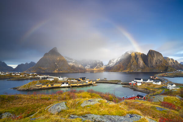 Panoramic and elevated view with rainbow of Hamnoy and bridges from Olenilsoya kystfort, Reine, Moskenes, Moskenesoya, Nordland, Lofoten, Norway, Northern Europe