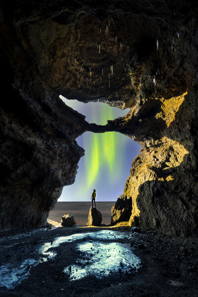 A tourist in Gigjagja cave during night with northern lights, Sudurland, Iceland, Northern Europe (MR)