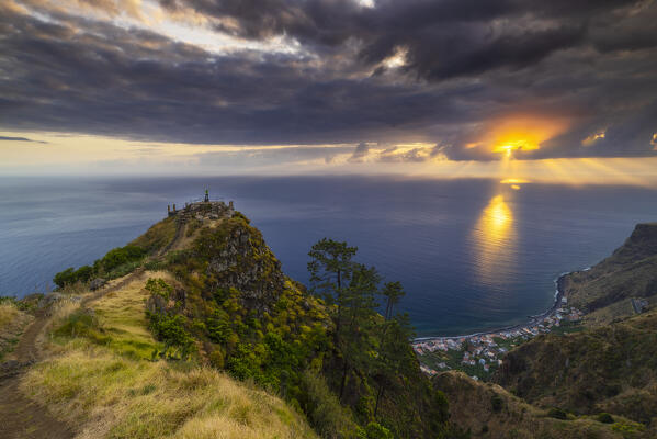 A tourist observes sunset from Miradouro da Raposeira, Paul do Mar, Fajã da Ovelha, Madeira, Portugal, Europe