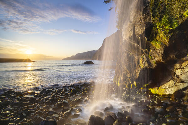 A waterfall in Seixal black sand beach during sunrise, Seixal, Porto Moniz, Madeira, Portugal, Europe