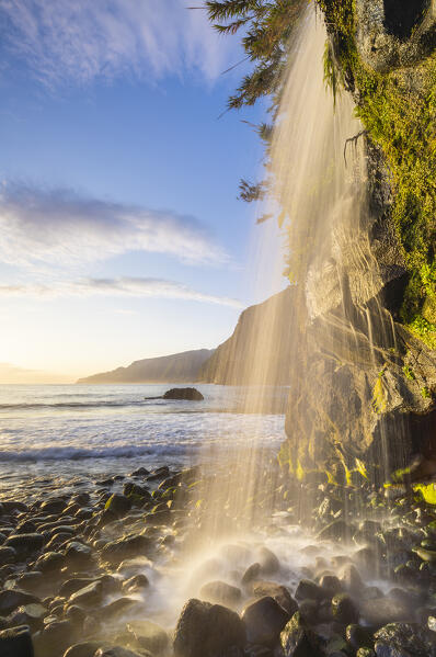 A waterfall in Seixal black sand beach during sunrise, Seixal, Porto Moniz, Madeira, Portugal, Europe
