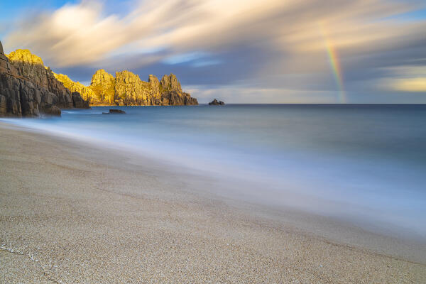 Logan Rock and Pedn Vounder beach with rainbow beach at sunset, St Levan, Treen, Penzance, Cornwall, England, Great Britain, United Kingdom
