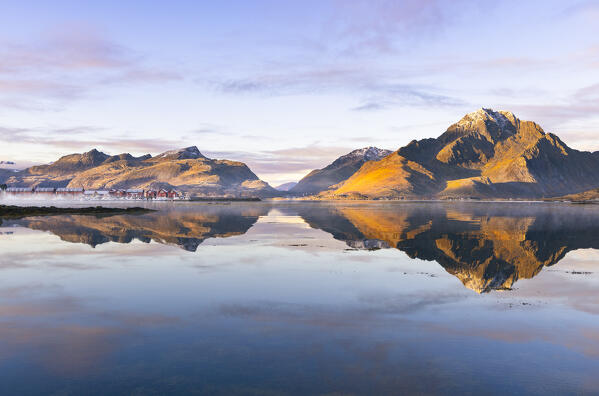 Mountains and rorbuer reflected in a Fjord during sunset, Leknes, Vestvagoy, Nordland, Lofoten Islands, Norway, Northern Europe