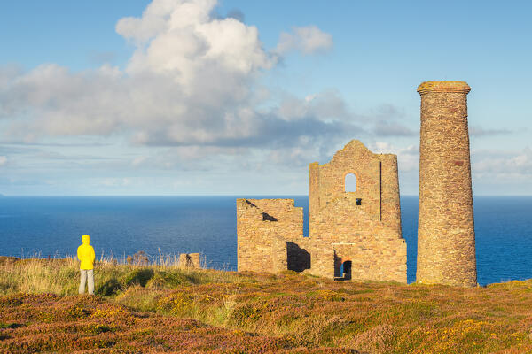 A tourist observes Wheal Coates and Chapel Port Mine during sunrise, Saint Agnes, Cornwall, England, Great Britain, United Kingdom