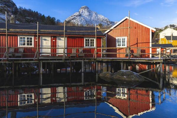 Reflections and Rorbuer in Nusfjord during winter, Flakstad, Flakstadoya, Nordland, Lofoten Islands, Norway, Northern Europe