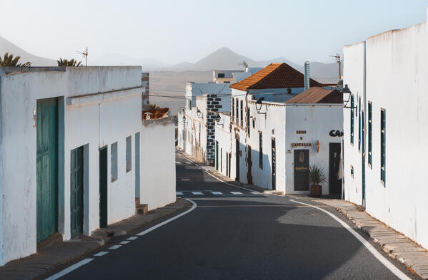 View of a road in Teguise and lava fields with volcanoes in the distance, Las Palmas, Lanzarote, Canary Islands, Macaronesia, Spain, Western Europe
