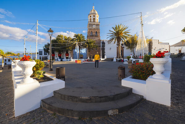 A tourist observes the church of Historical center of Teguise during sunrise, Las Palmas, Lanzarote, Canary Islands, Macaronesia, Spain, Western Europe