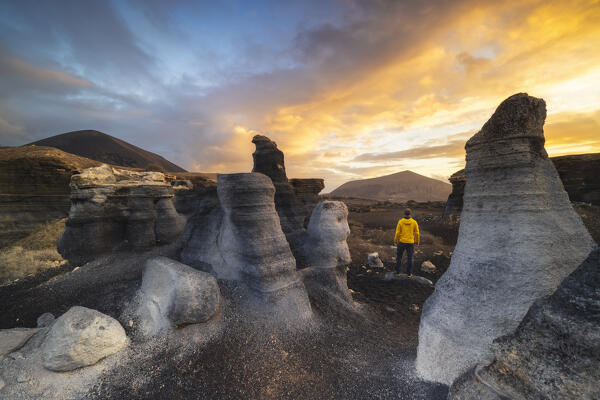 A tourist observes sunrise at Stratified city in Lanzarote, Teseguite, Las Palmas, Lanzarote, Canary Islands, Macaronesia, Spain, Western Europe