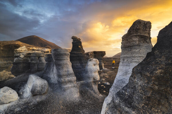 A tourist observes sunrise at Stratified city in Lanzarote, Teseguite, Las Palmas, Lanzarote, Canary Islands, Macaronesia, Spain, Western Europe (MR)