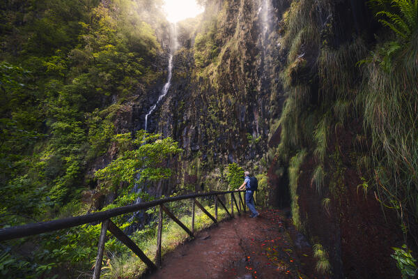 A tourist admires Risco waterfall, Levada do Risco, Rabacal, Paul da Serra, Madeira region, Portugal, Western Europe