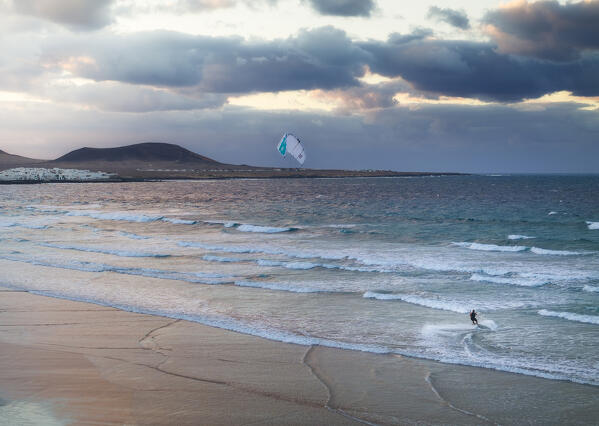 Aerial view of a man kitesurfing at Famara beach with Caleta de Famara in background, Caleta de Famara, Las Palmas, Lanzarote, Canary Islands, Macaronesia, Spain, Weste