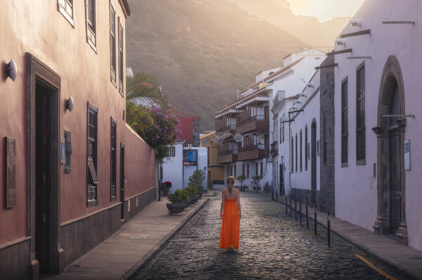 A woman walks in a road of Garachico at sunset, Santa Cruz de Tenerife, Tenerife, Canary Islands, Macaronesia, Spain, Western Europe 
