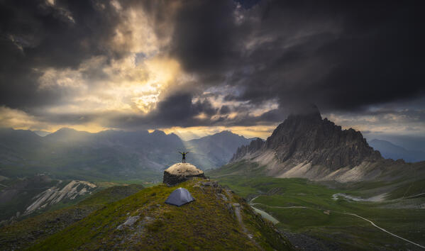 Panoramic view of a trekker at Colle D’Andoccia in front of Rocca la Meja at sunset during summer, Cuneo, Piedmont, Italy, Southern Europe